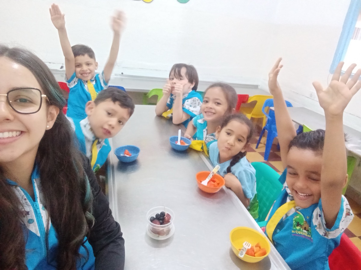Niños felices comiendo frutas juntos